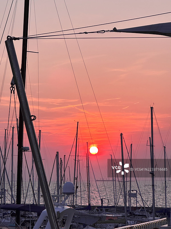 意大利的的里雅斯特，海上日落时的帆船剪影图片素材