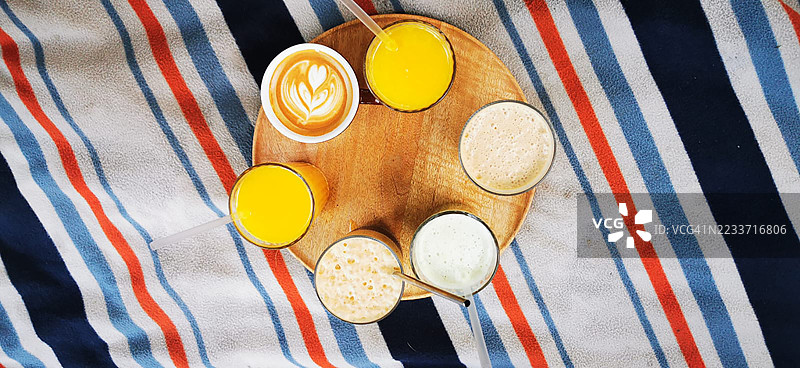 木托盘上的各种饮料，背景为条纹图案图片素材