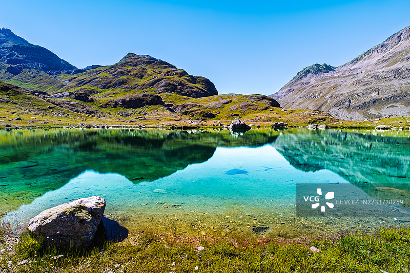 宁静的湖泊映衬着清澈蓝天下的雄伟山脉，泽尔内茨，瑞士图片素材