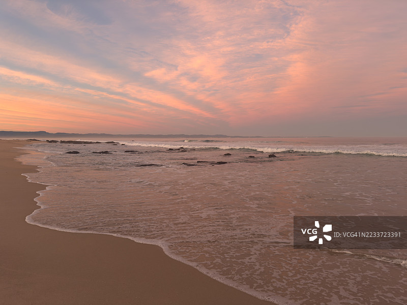宁静的海滩日落，粉色和橙色的天空，杰弗里湾，南非图片素材