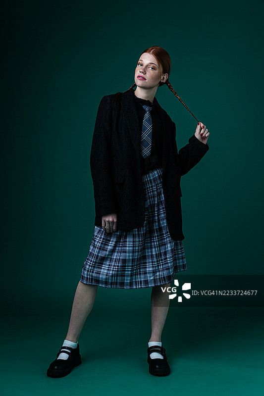 自信的女性穿着宽大的西装外套和格子裙图片素材