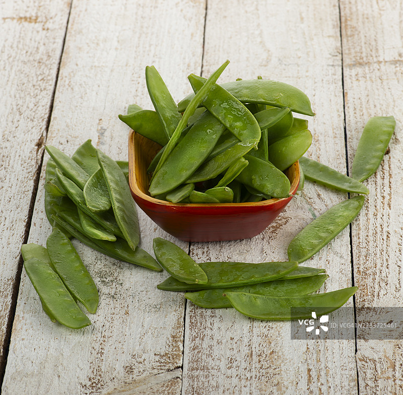 新鲜的雪豆放在乡村风格的木碗里图片素材