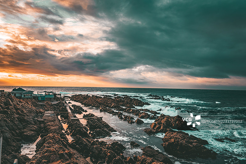 南非莫塞尔湾岩石海岸线和海洋上的戏剧性日落图片素材