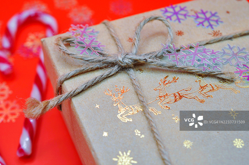 用棕色纸包裹的圣诞礼物，上面装饰着雪花图案图片素材