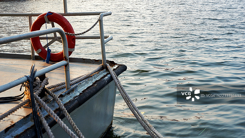 停靠在平静海面上的船只特写，旁边有一个救生圈，印度尼西亚图片素材