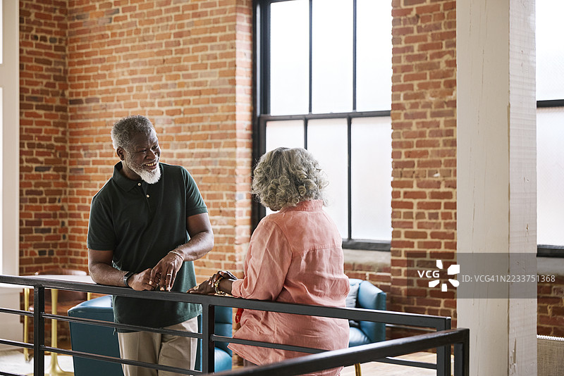 成熟的商人在现代办公室与女性同事交谈图片素材