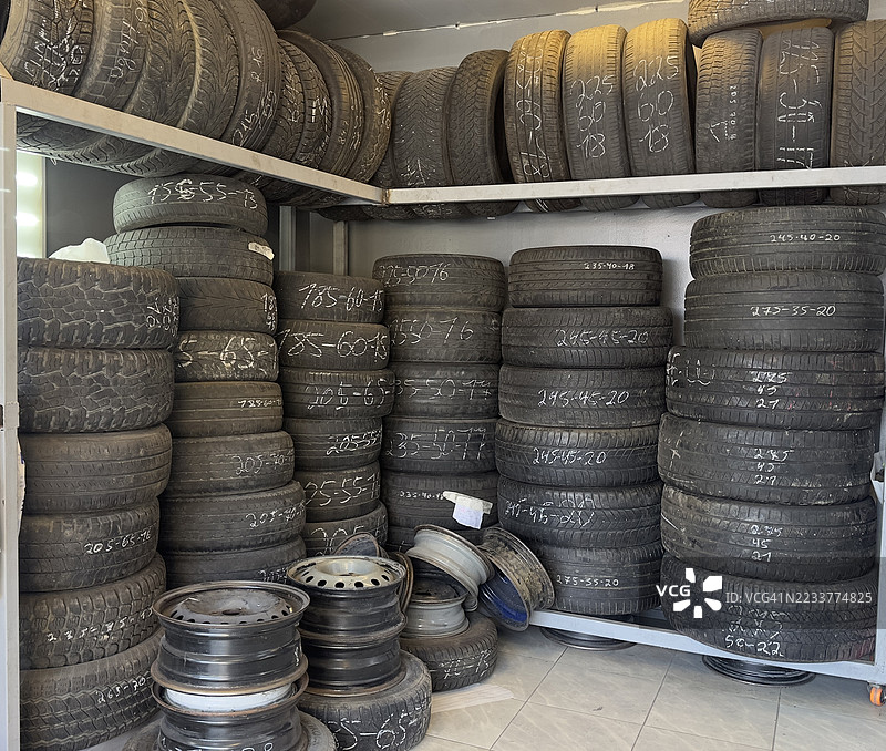 存放在储藏室里的堆叠二手汽车轮胎和轮圈图片素材