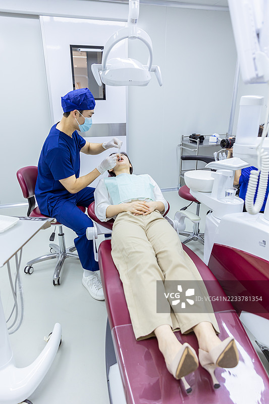 牙医正在检查女性患者的牙齿图片素材