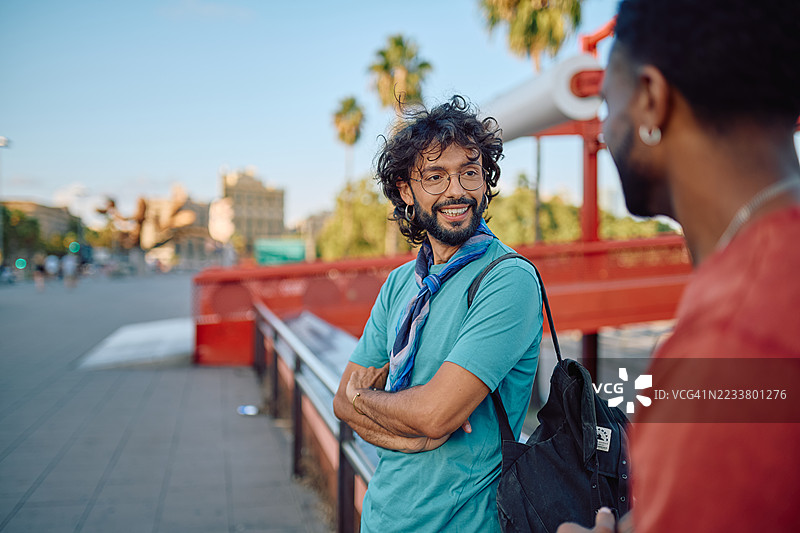 在巴塞罗那的一座桥上，两名年轻男子正在交谈图片素材