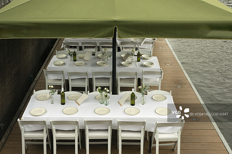 桌子上铺着白色桌布，摆放着盘子和酒瓶图片素材