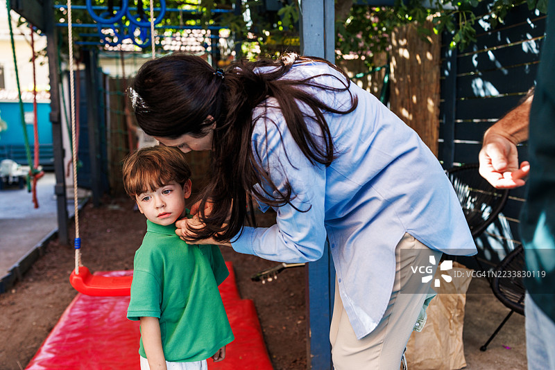 年轻的女保姆在户外帮助小男孩图片素材