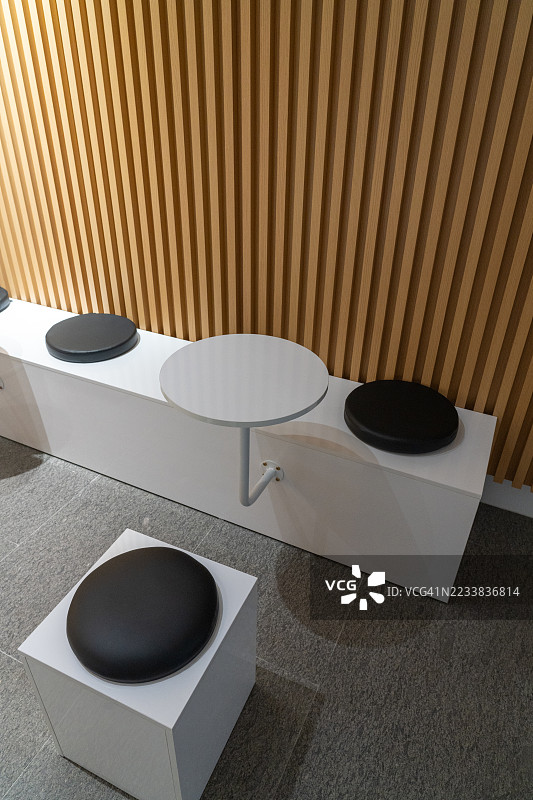 现代简约风格的候车区，配有圆形桌子和软垫长椅图片素材