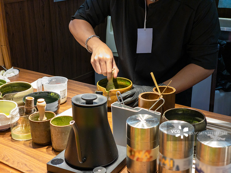 在茶台上用竹制茶筅打抹茶图片素材