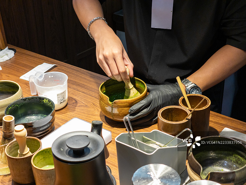 在茶台上用竹制茶筅打抹茶图片素材