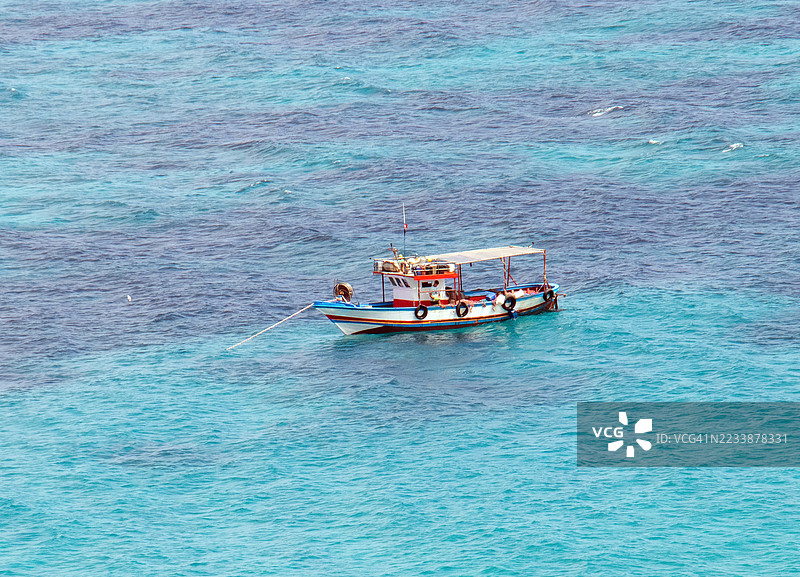 高角度视图的船漂浮在碧绿色的海洋中图片素材