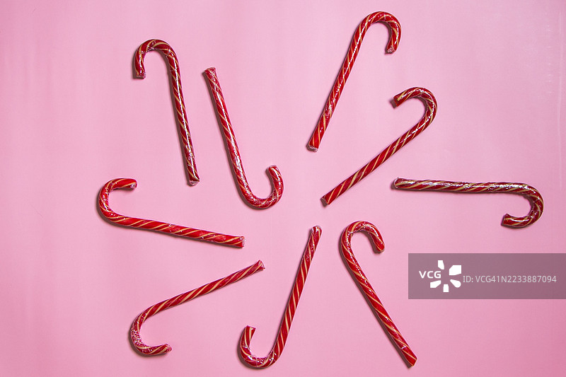 在粉色背景上排列成圆形的糖果手杖图片素材