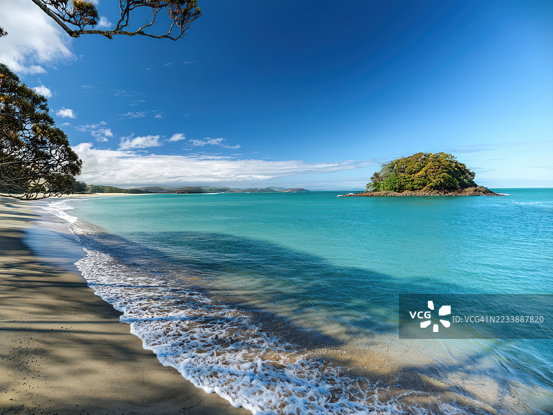 宁静的海滩，碧蓝的海洋和清澈的蓝天下的岛屿，澳大利亚，海湾群岛图片素材