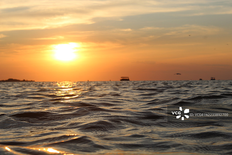 宁静的海洋日落与金色天空的倒影图片素材