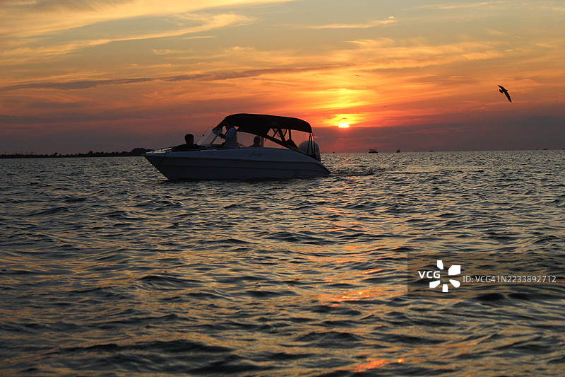 日落时海上船只的剪影图片素材