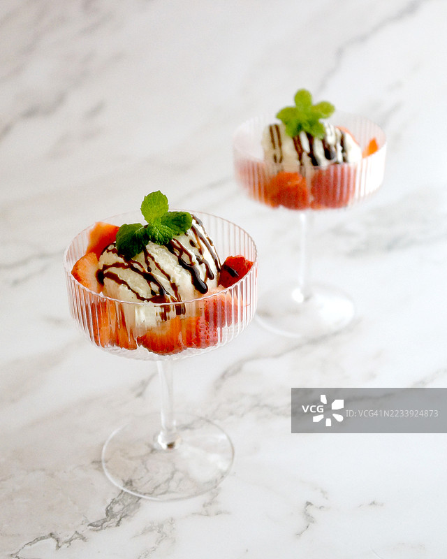 香草冰淇淋配草莓、巧克力酱和薄荷，盛在杯子里图片素材