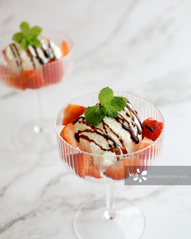 香草冰淇淋配草莓、巧克力酱和薄荷，盛在杯子里图片素材
