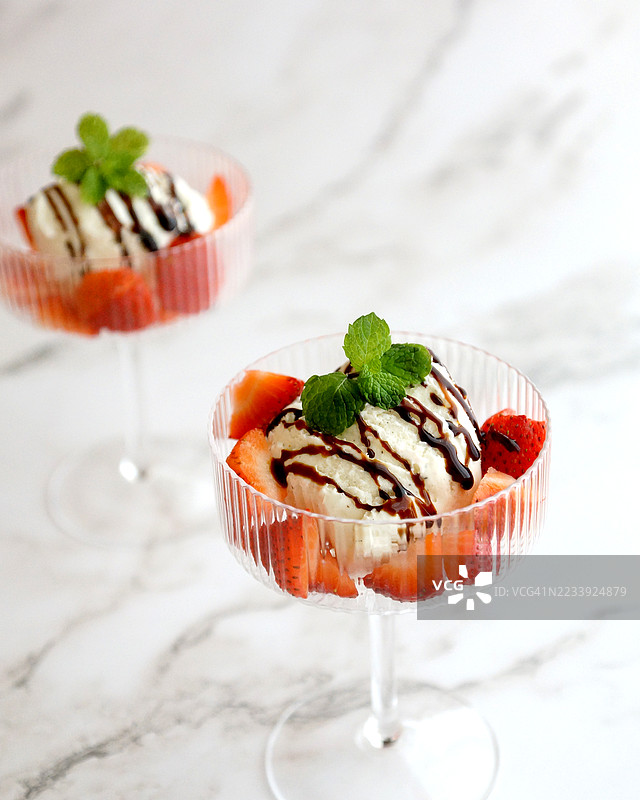 香草冰淇淋配草莓、巧克力酱和薄荷，盛在杯子里图片素材