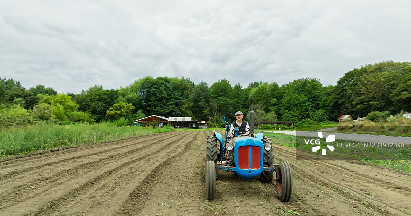 约克郡农夫戴着平顶帽驾驶复古拖拉机图片素材
