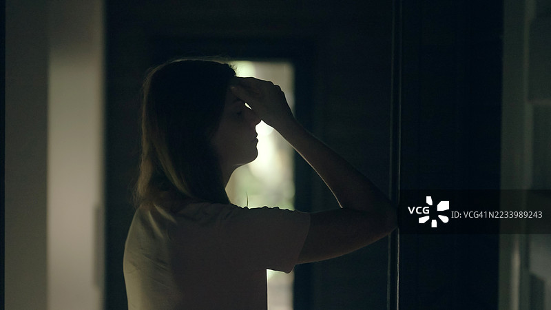 女孩坐在黑暗的房间里，经历心理崩溃——抑郁。图片素材