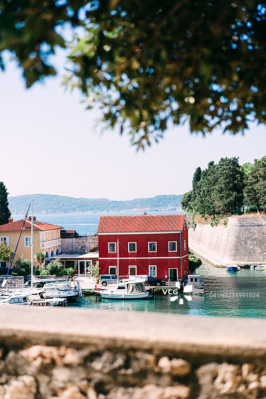 克罗地亚扎达尔的历史海滨建筑旁停泊的船只与风景如画的海岸港口图片素材