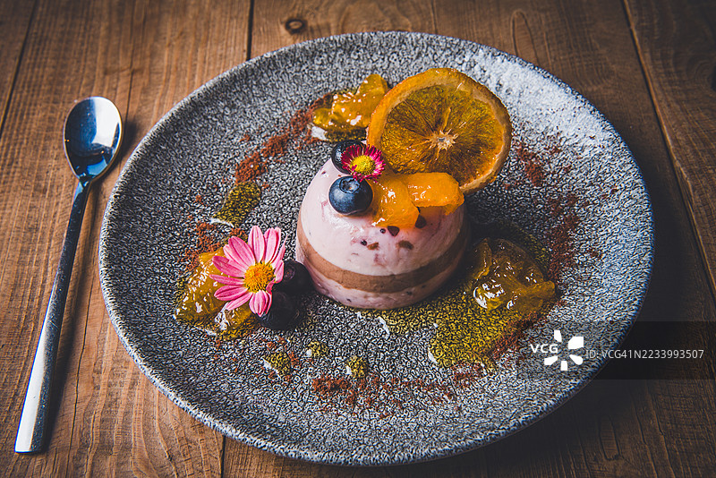 优雅的甜点盘，配有新鲜水果和可食用花卉装饰图片素材