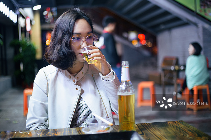 亚洲年轻女性在户外用餐和饮水图片素材