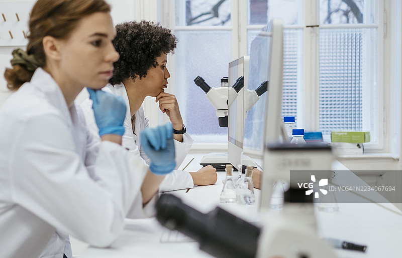 专注的女学生在大学科学实验室合作图片素材