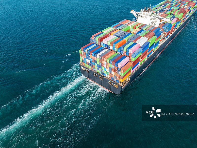 无人机航拍视角的货船满载集装箱在海上航行图片素材