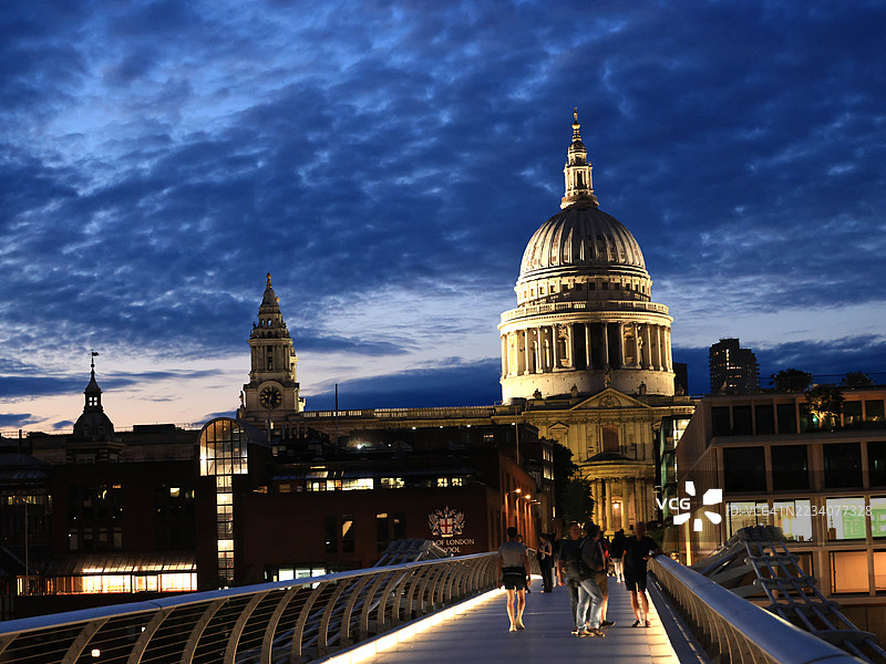 伦敦千年桥上的圣保罗大教堂和人们在夜晚的景象图片素材