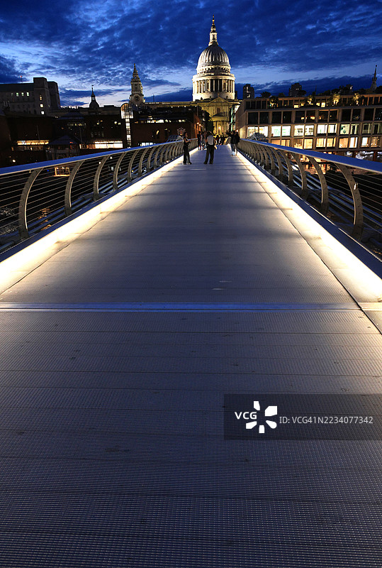 伦敦千年桥上的圣保罗大教堂和人们在夜晚的景象图片素材
