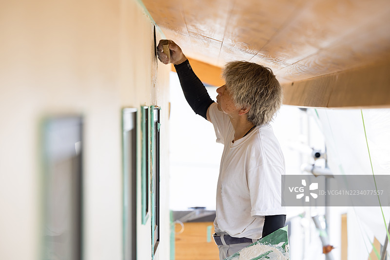 一名抹灰工正在给一栋正在建设中的房屋外墙抹灰。图片素材