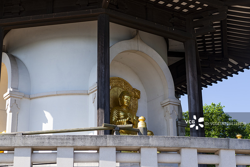 一尊佛像静静地安放在和平塔的一个小凹处，在伦敦巴特西公园的绿意中散发着宁静。图片素材