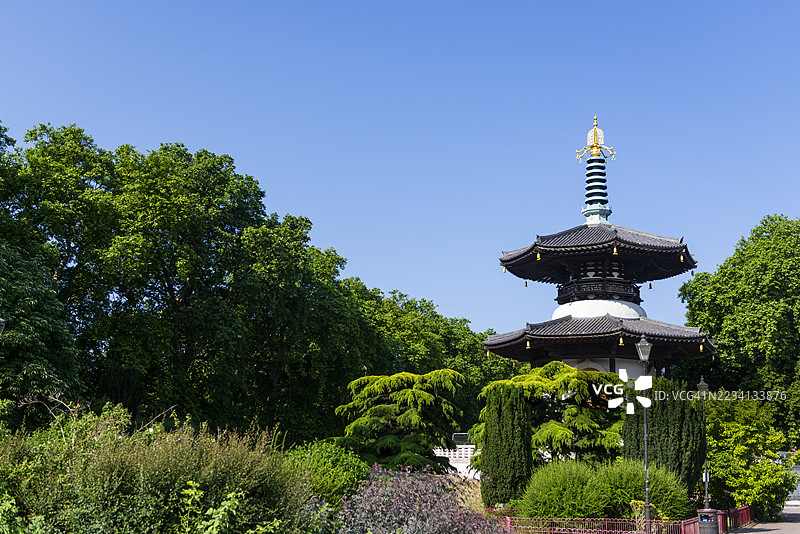 巴特西公园的和平塔，优雅地矗立在泰晤士河旁，周围环绕着树木，位于英国伦敦。图片素材