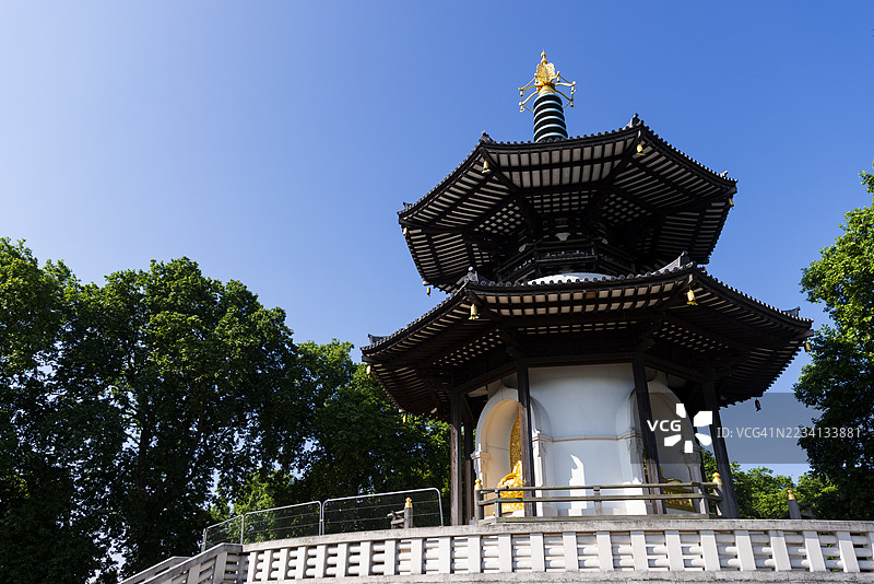 巴特西公园的和平塔，优雅地矗立在泰晤士河旁，周围环绕着树木，位于英国伦敦。图片素材