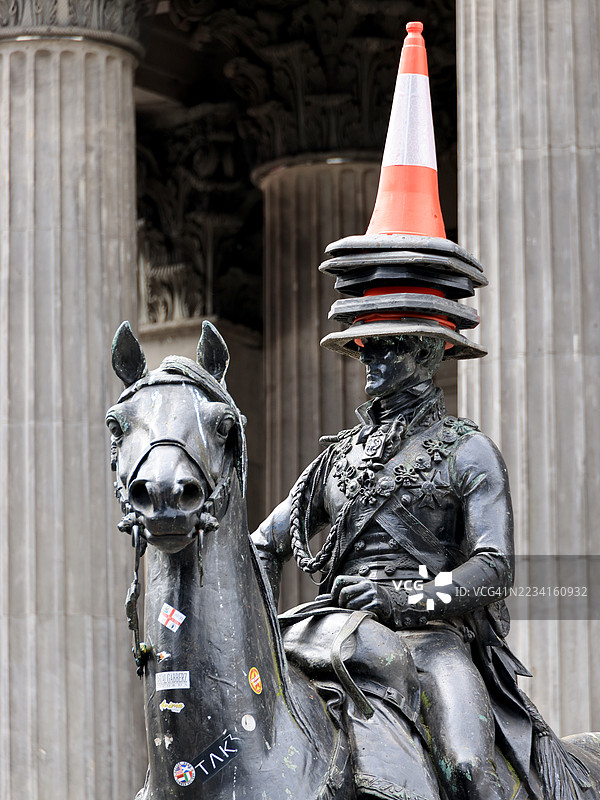 格拉斯哥，苏格兰，威灵顿公爵骑马雕像头顶堆满了锥形交通标志图片素材