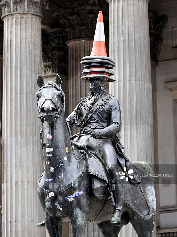 格拉斯哥，苏格兰的威灵顿公爵骑马雕像，头上顶着一堆锥形物。图片素材
