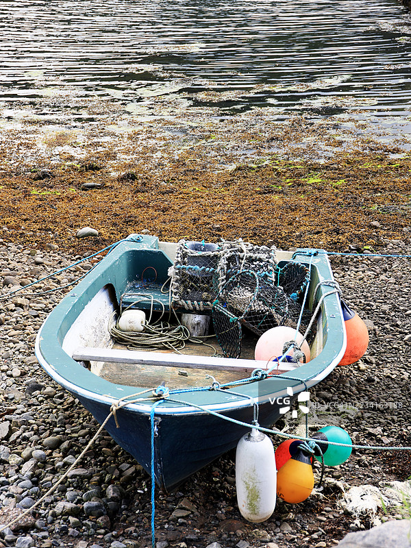 一艘渔船停靠在苏格兰天空岛洛赫朗的岩石海岸上图片素材