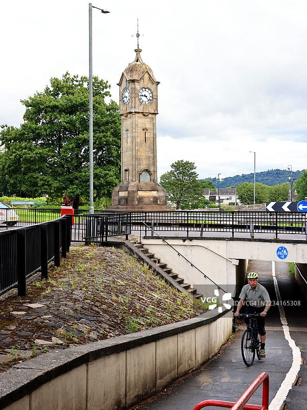 骑自行车的人与苏格兰斯特灵的桥钟塔。图片素材