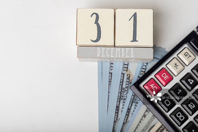 12月31日标志着年末，手边有现金和计算器用于预算。图片素材