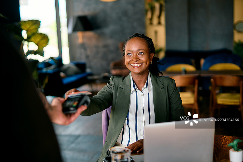 微笑的女商人在咖啡馆进行无接触支付图片素材