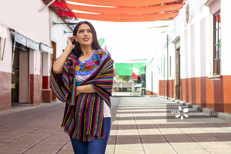 一位女性走在乌鲁阿潘市中心的肖像图片素材