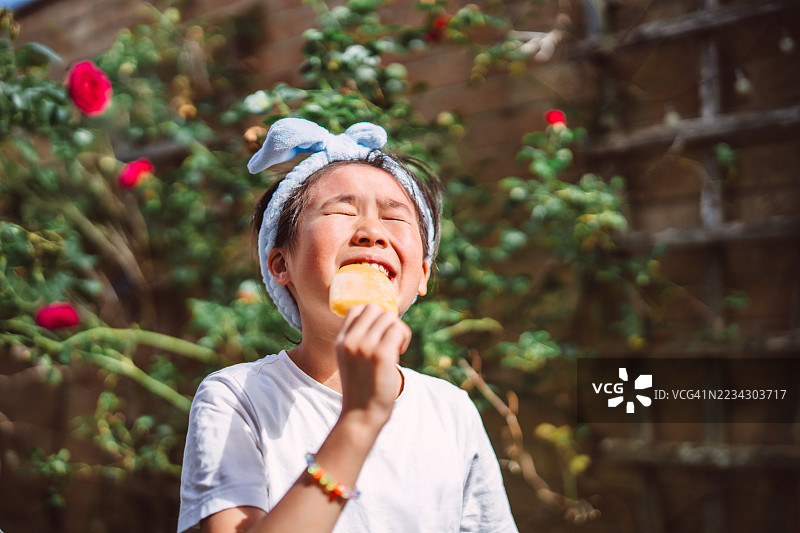 孩子在花园里享受夏季冰棒图片素材