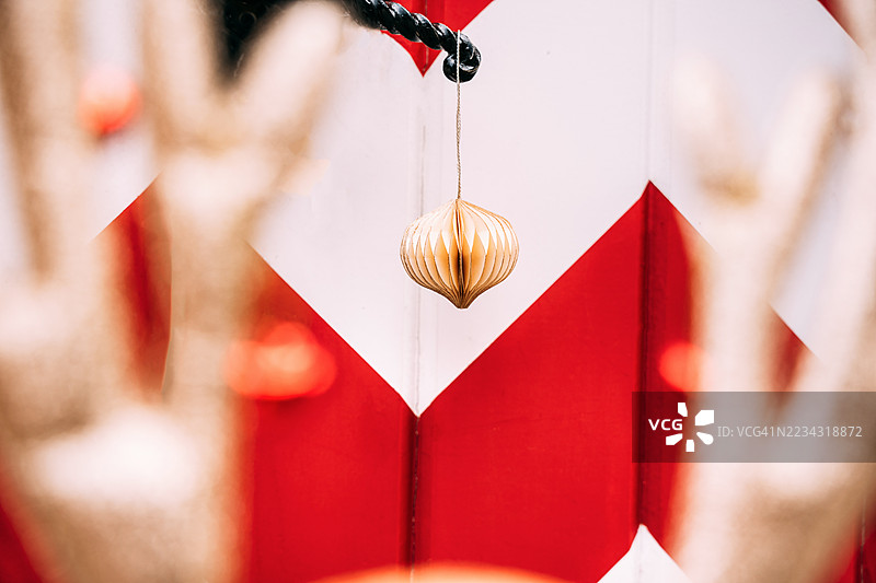 可爱的驯鹿鹿角之间，纸质圣诞装饰挂在复古的门把手上。图片素材