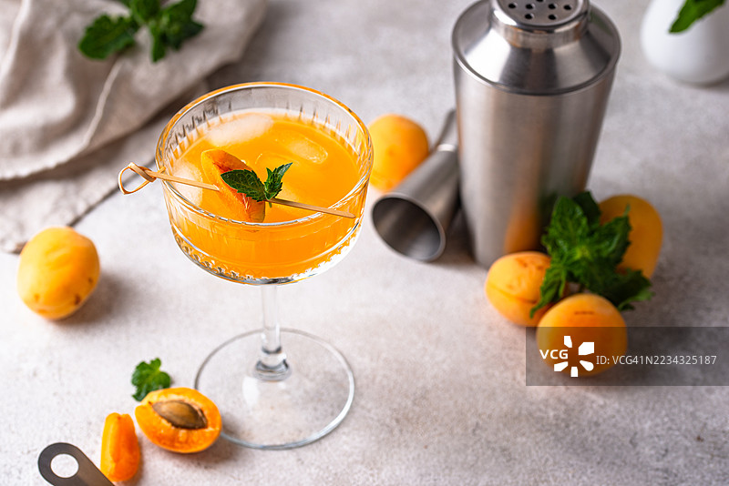 清新的杏子鸡尾酒，配有薄荷装饰，摆放在桌子上图片素材