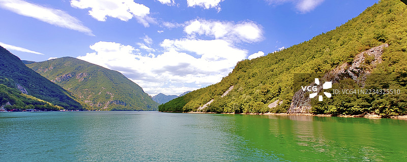 宁静湖泊的美丽景色，四周被郁郁葱葱的山脉环绕，天空色彩斑斓，斯雷布雷尼察，波斯尼亚和黑塞哥维那图片素材